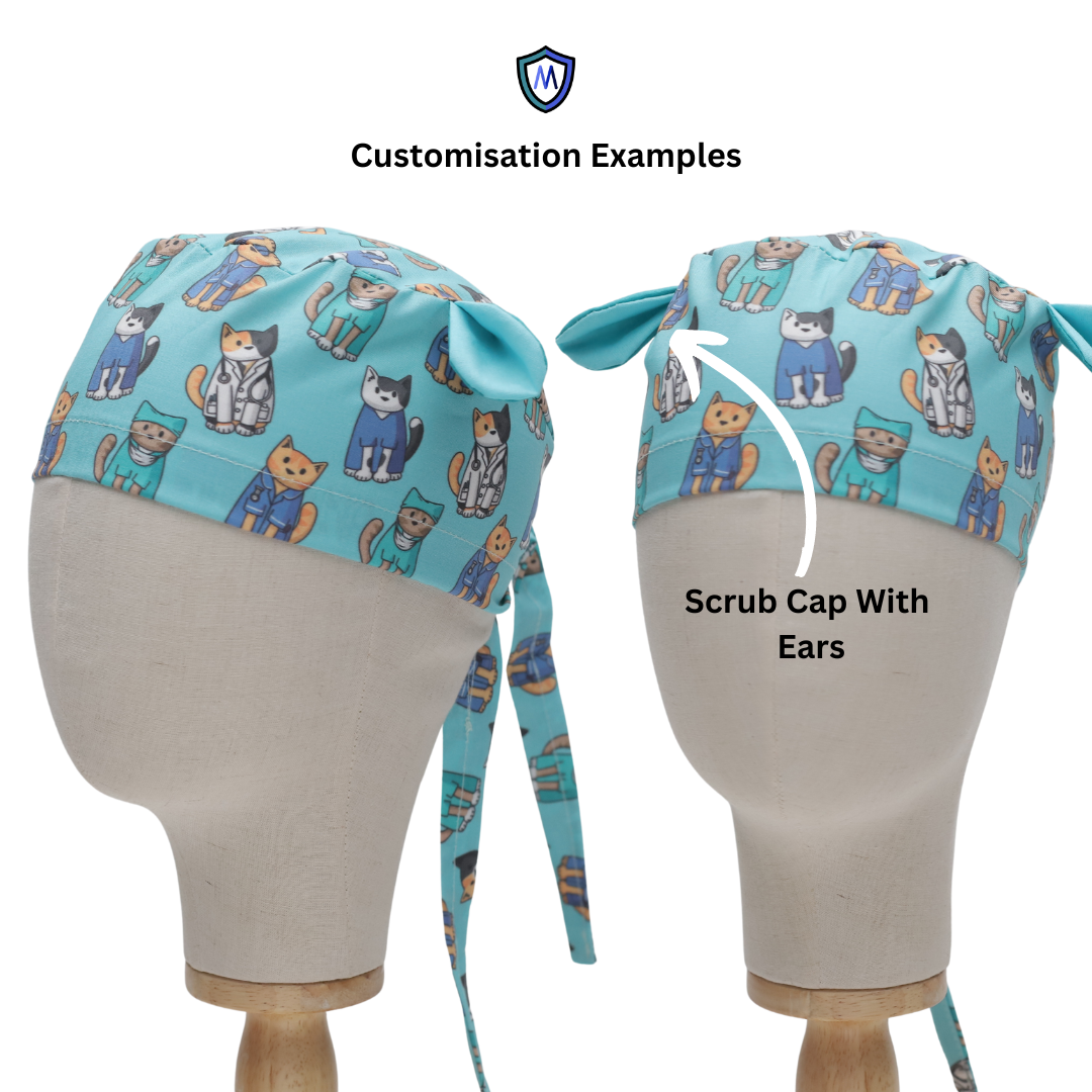Two mannequin heads display light blue scrub caps with cartoon cats in various costumes. One cap includes cat ear-shaped fabric on top. Text reads Customisation Examples and Scrub Cap With Ears.