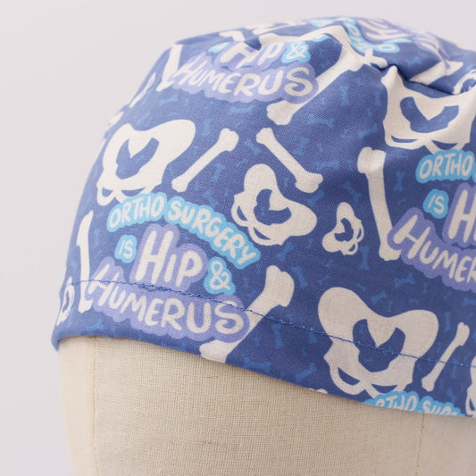 Blue custom scrub cap with hip and humerus bone pattern, handmade by Medicus Caps