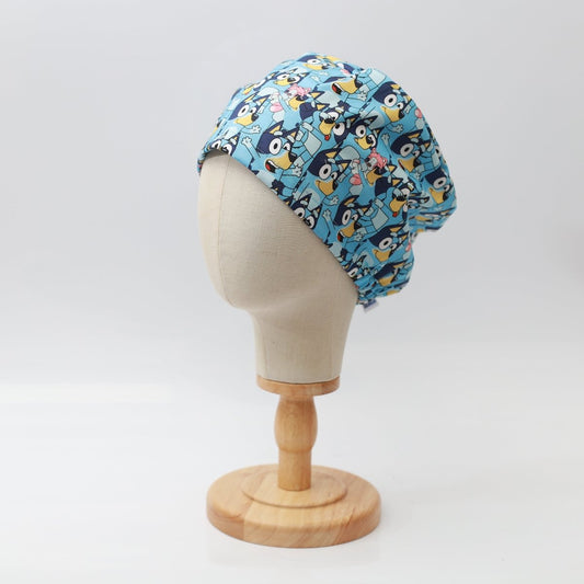 Blue Medicus Scrub Cap with a fun crowd pattern, displayed on a mannequin. Playful and customizable design for healthcare professionals.