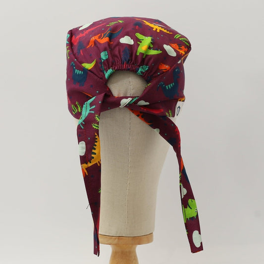 Gorro quirúrgico morado con diseño de dinosaurios