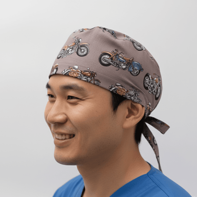 Grey vintage motorcycle pattern scrub cap with tie-back closure worn by smiling healthcare worker