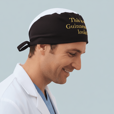 Black scrub cap with cream pint design and golden text for medical professionals