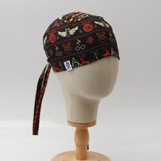 Mannequin head wearing Medicus Scrub Cap with Harry Potter Christmas jumper print, on a wooden stand against a white backdrop.