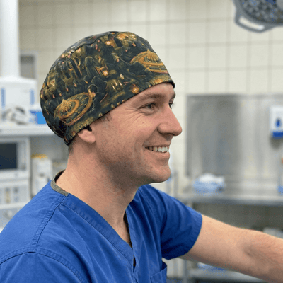 Medieval castle design scrub cap with golden yellow pattern on dark background