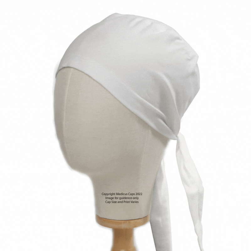 Displayed on a beige mannequin head, the Classic Plain Scrub Cap from Medicus Scrub Caps exudes elegance. Its white design is functional yet stylish, tied at the back with cascading ends against a white background. Available in XS to 2XL sizes and 22 colors.