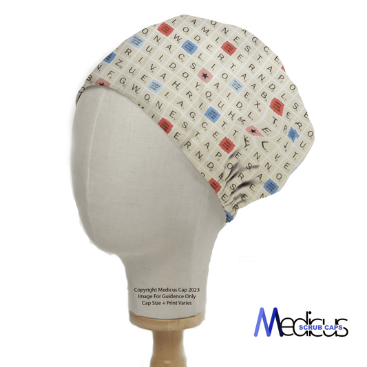 A mannequin head displays the Scrabble Board Classic Vintage Scrub Cap by Medicus Scrub Caps, featuring an off-white crossword grid design with multicolored letters, perfect for word enthusiasts. The playful print resembles a Scrabble board, with the logo elegantly on the bottom right.
