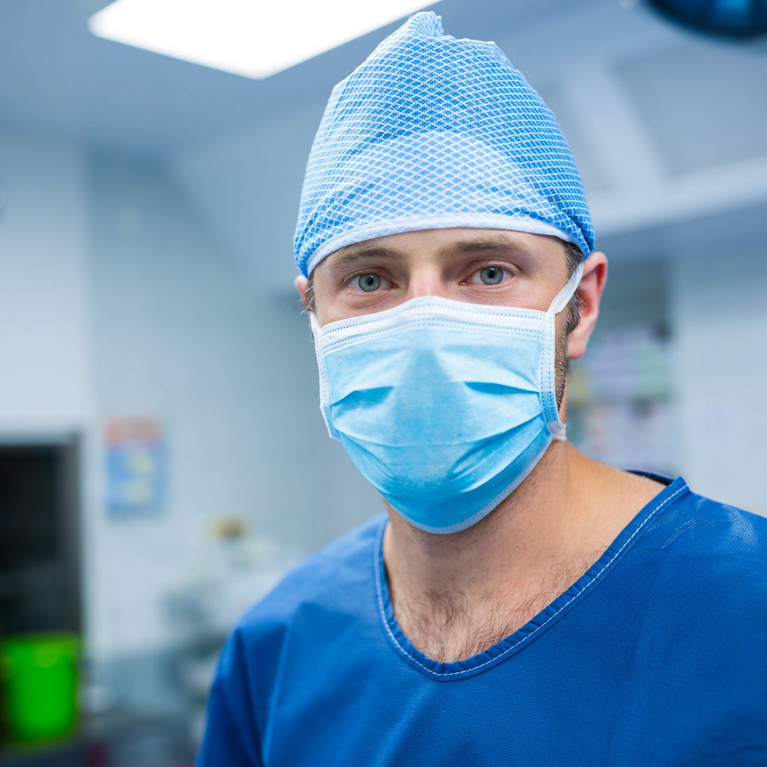 Surgeon wearing a surgical mask and cap in an operating room