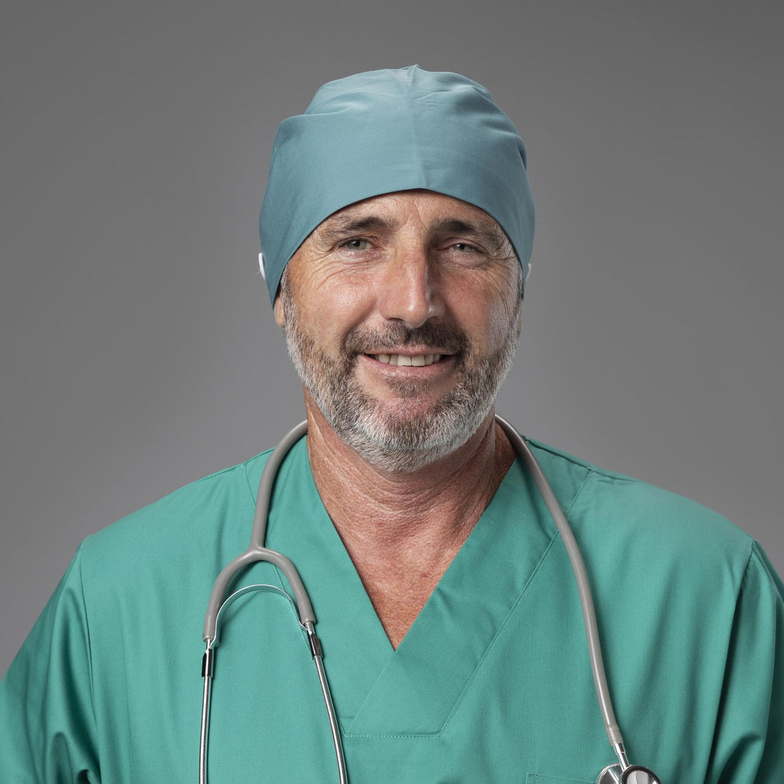 Male surgeon wearing a teal scrub cap