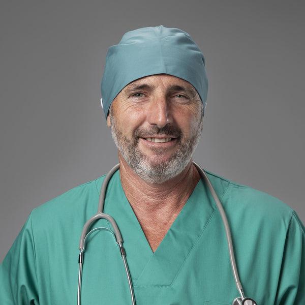 Male surgeon wearing a teal scrub cap