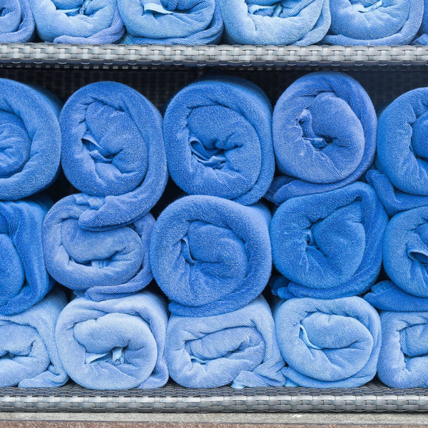 Rolled blue medical scrubs stacked on shelves