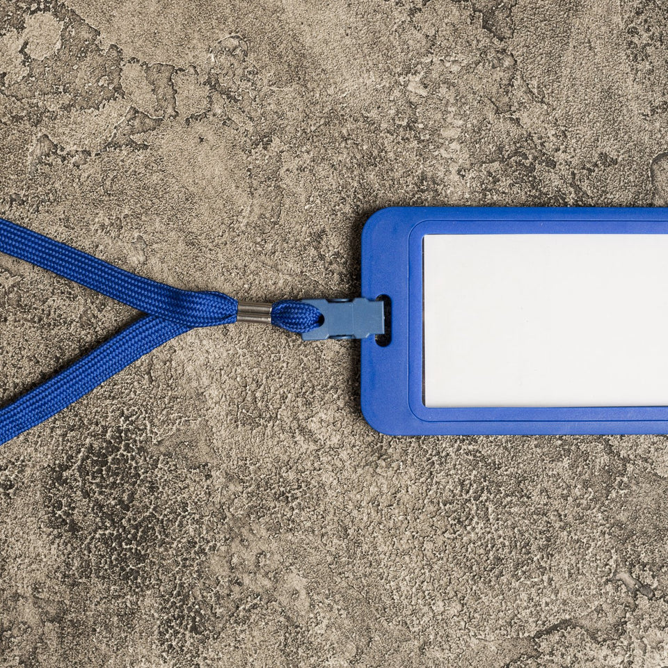 Blue lanyard with an ID badge holder on a desk