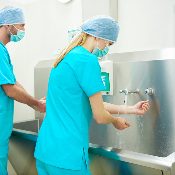 Two surgeons scrubbing their hands before surgery