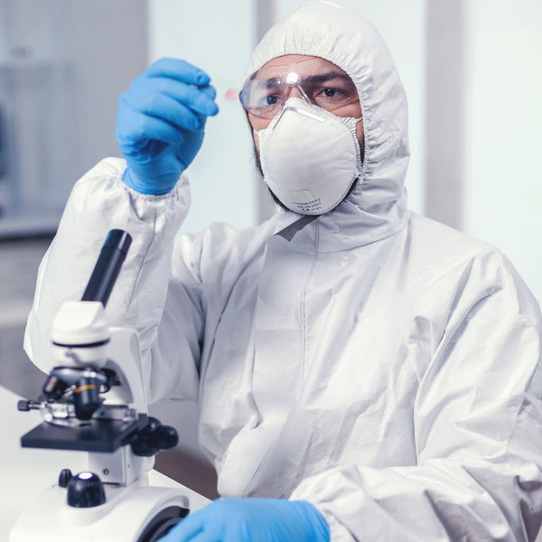 Medical scientist in PPE examining a sample