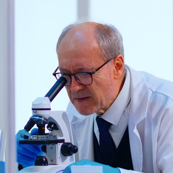 Lab technician examining bacteria samples under a microscope