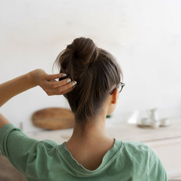 Woman with long hair tied into a bun