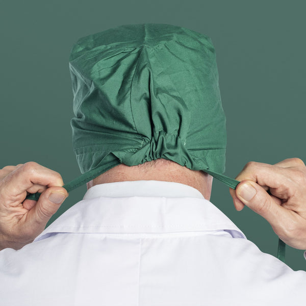Surgeon tying the ties of a surgical cap