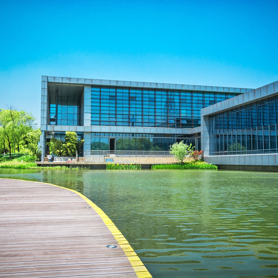 Modern building surrounded by greenery and water