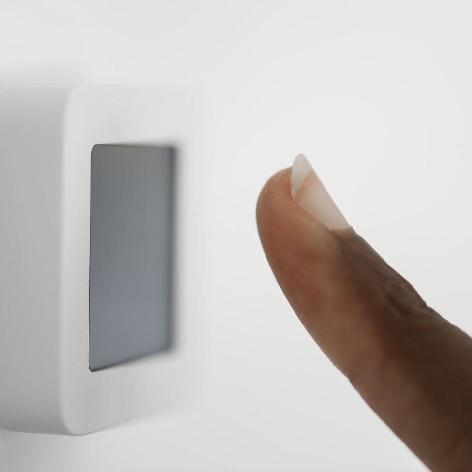 Finger pressing a wall control switch