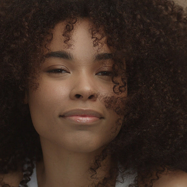Close-up portrait of a smiling woman with natural curly afro hair