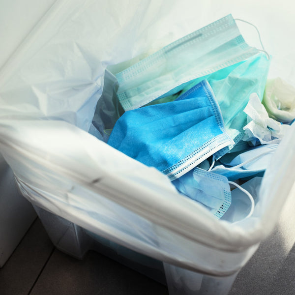 Used disposable medical PPE discarded in a waste bin