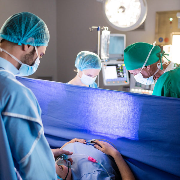 Surgical team performing a caesarean delivery in an operating theatre