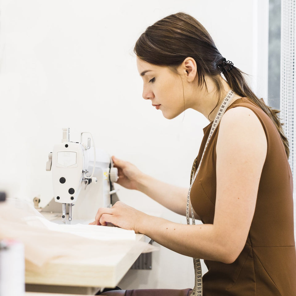 Seamstress working at a sewing machine in a garment workshop