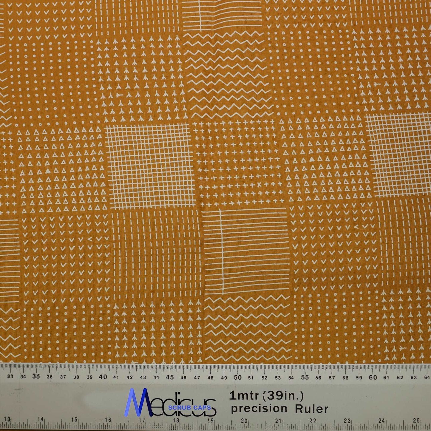 Abstract Lines On Mustard Theatre Scrub Cap from Medicus Scrub Caps, featuring a geometric patchwork design in white on a mustard background.