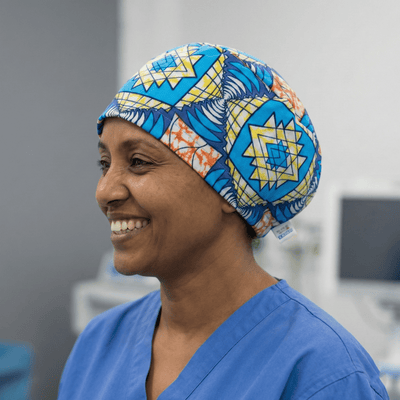 African Blue Starburst Scrub Cap (Aqua, Navy, Sunshine Yellow & Coral) scrub cap shown on model