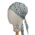 On a mannequin head, the Anaesthetist ABCs Scrub Cap by Medicus Scrub Caps features coffee cups, stethoscopes, and vials, emphasizing anesthesia and teamwork with a neat tie-back.