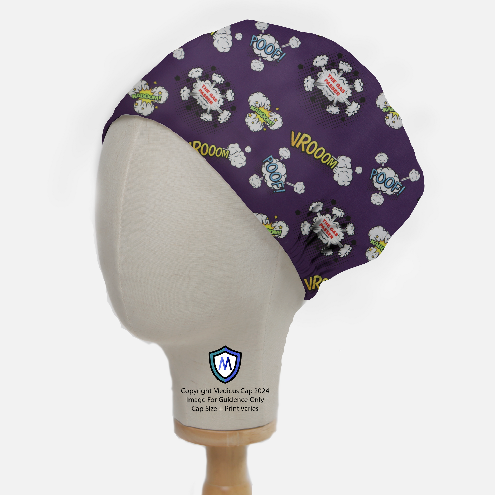 A mannequin head displays a Medicus Scrub Caps Anaesthetist Gas Passer scrub cap with a purple comic-themed design featuring words like POOF! and VROOM!.