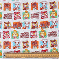 Close-up of Animal Crossing cartoon fabric with characters in square frames and ruler for scale.