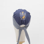 A mannequin head showcases the Mullet Version: Make Your Own Custom Printed Scrub Cap by Medicus Scrub Caps, featuring a two-tone design and a crest emblem.