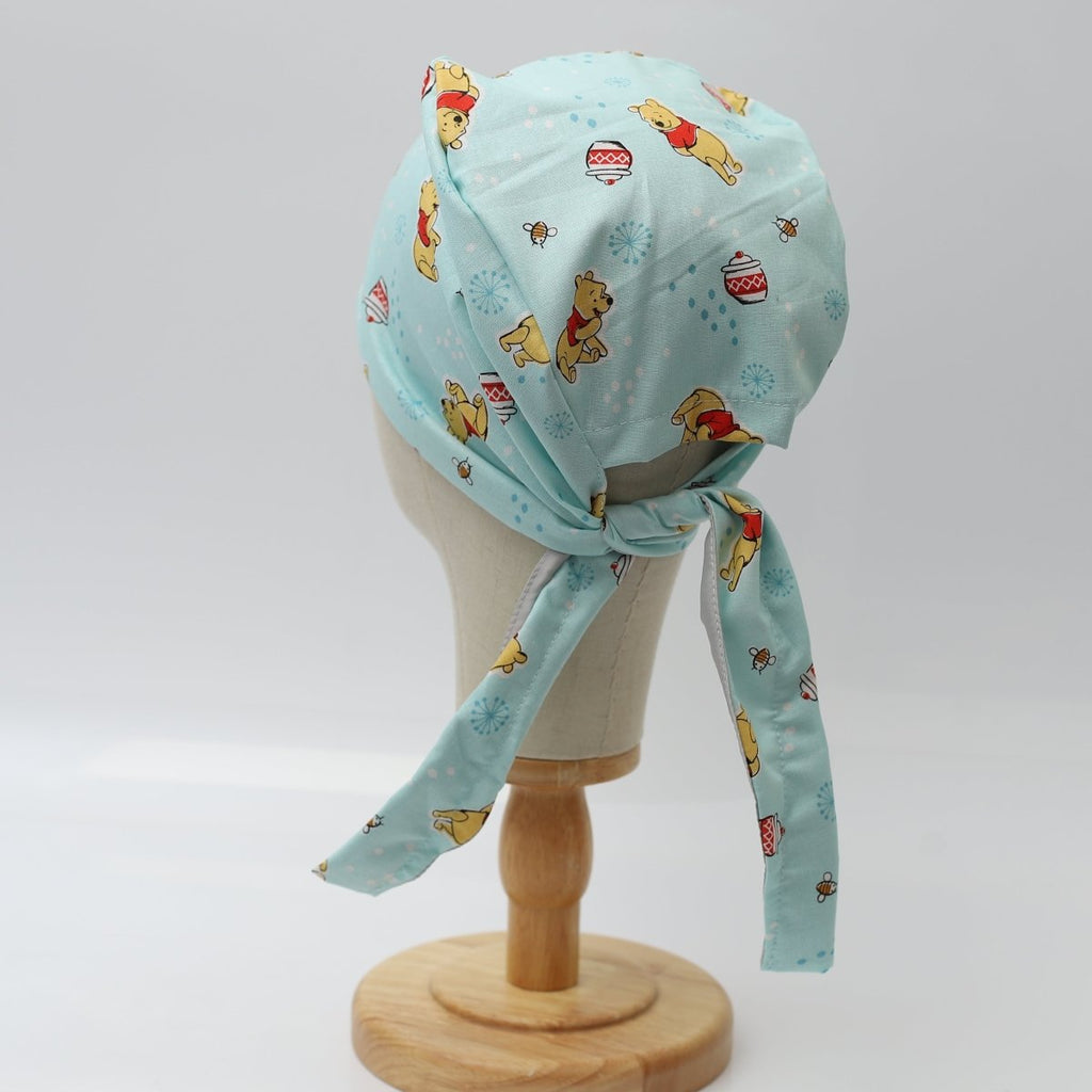 Custom blue scrub cap by Medicus Caps featuring cute bear and honey pot print. Back view with adjustable ties, handmade surgical cap made to order.