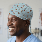 Bees + Flowers On Teal scrub cap shown on model