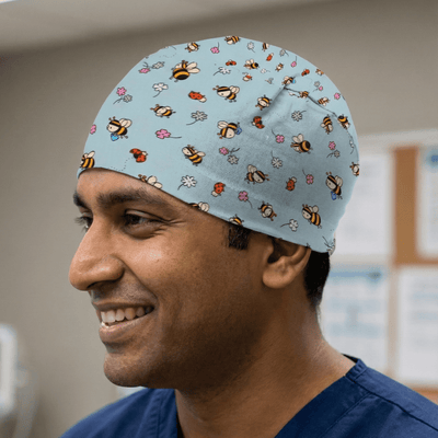 Bees + Flowers On Teal scrub cap shown on model