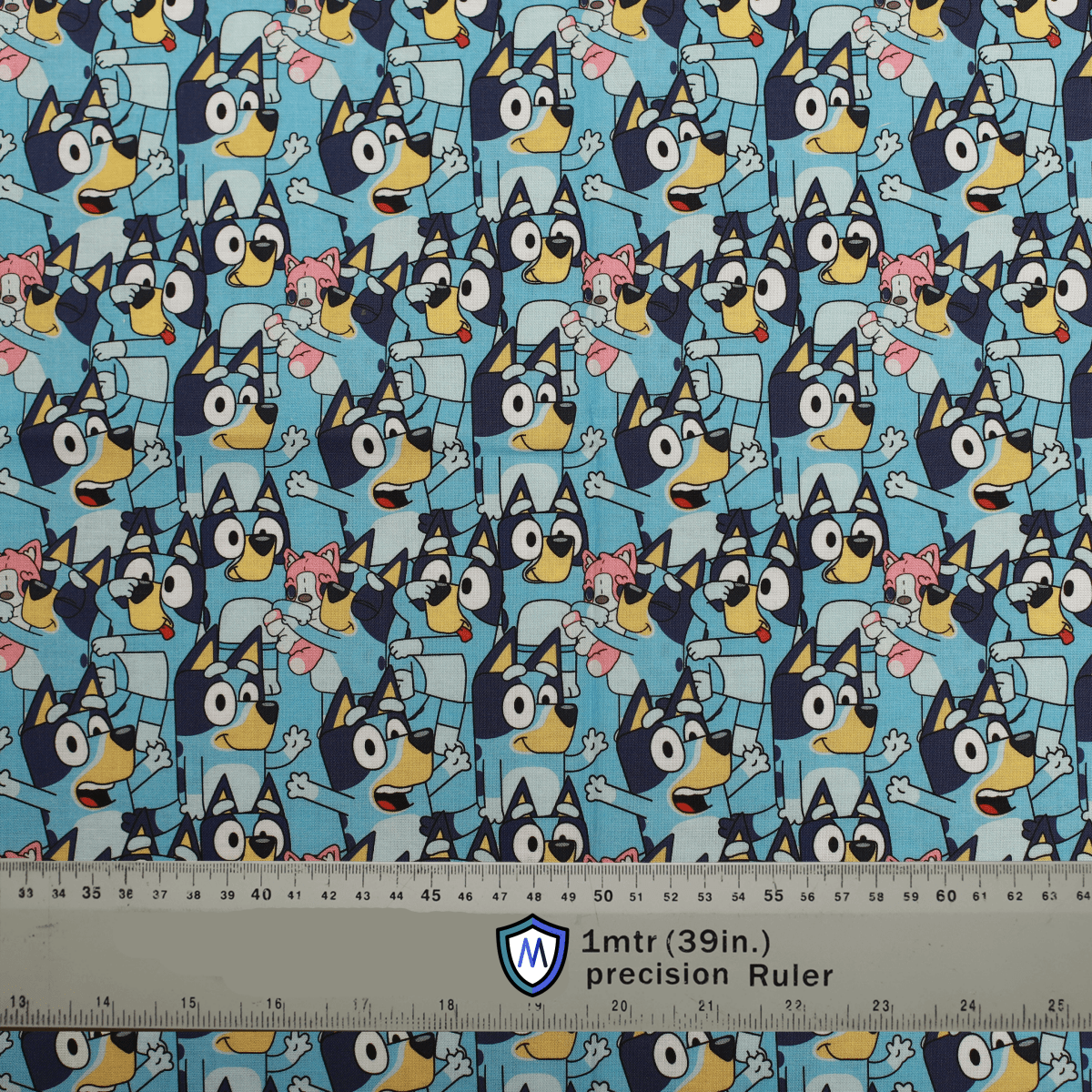 Bluey-themed Medicus Scrub Cap fabric featuring a fun, crowded pattern of Bluey and friends on a light blue background. Ruler for scale.