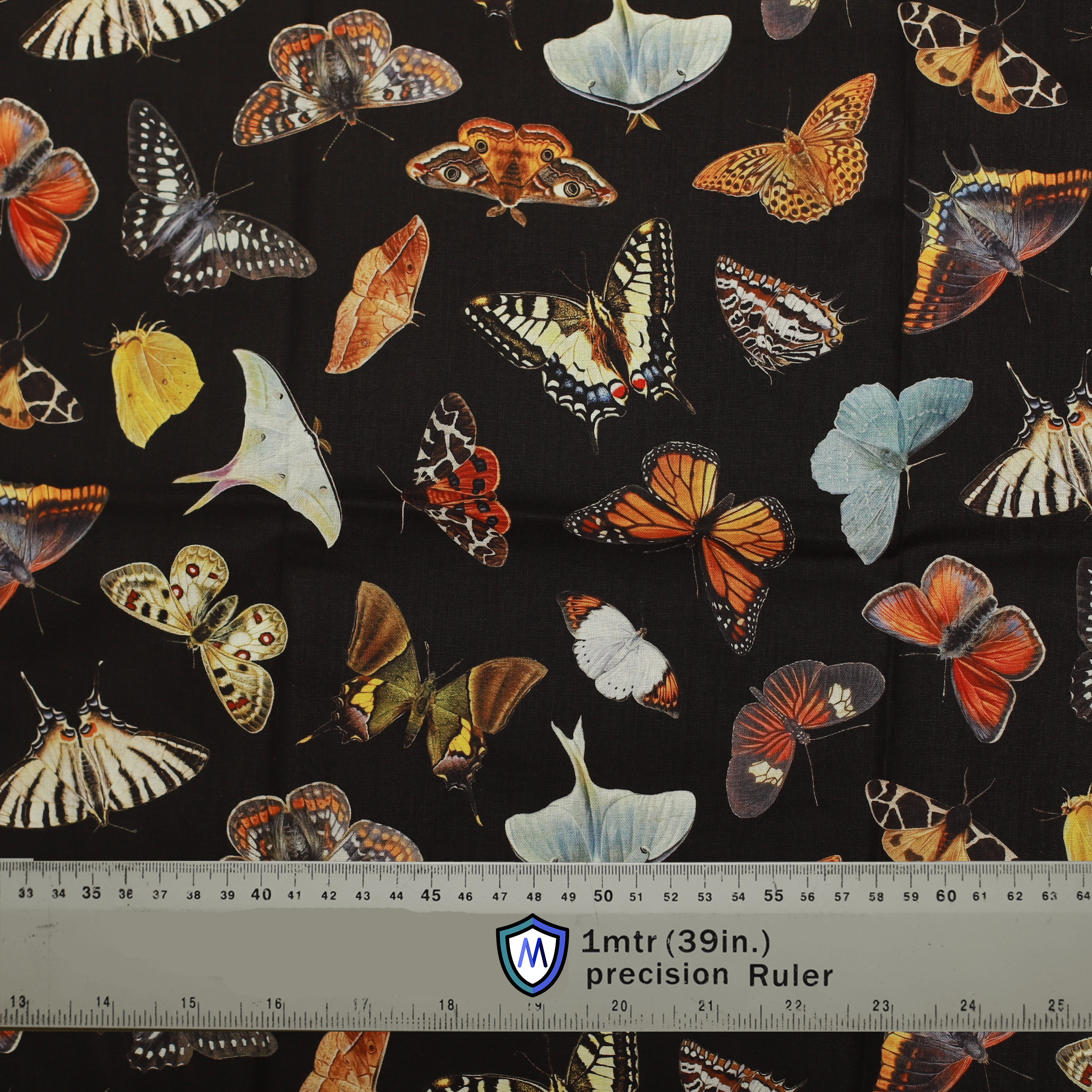 Fabric sample for Medicus Scrub Caps featuring colorful butterflies and moths on a black background. 1-meter ruler for scale. @butterflies-scrub-cap