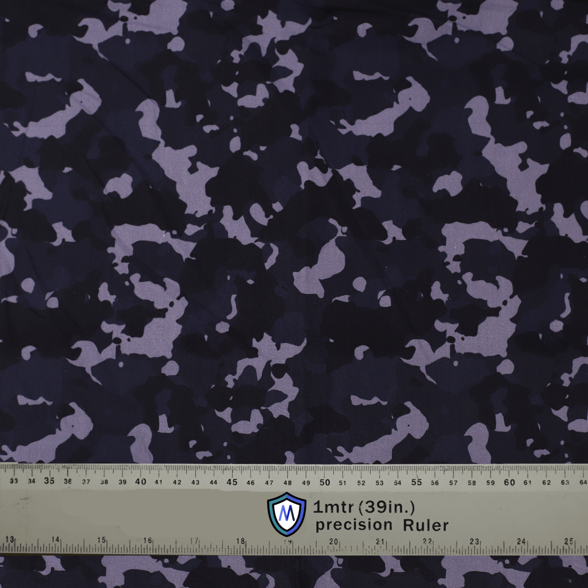 Dark camouflage fabric used for Medicus Scrub Caps, with a precision ruler for scale. Ideal for stylish and functional medical headwear.