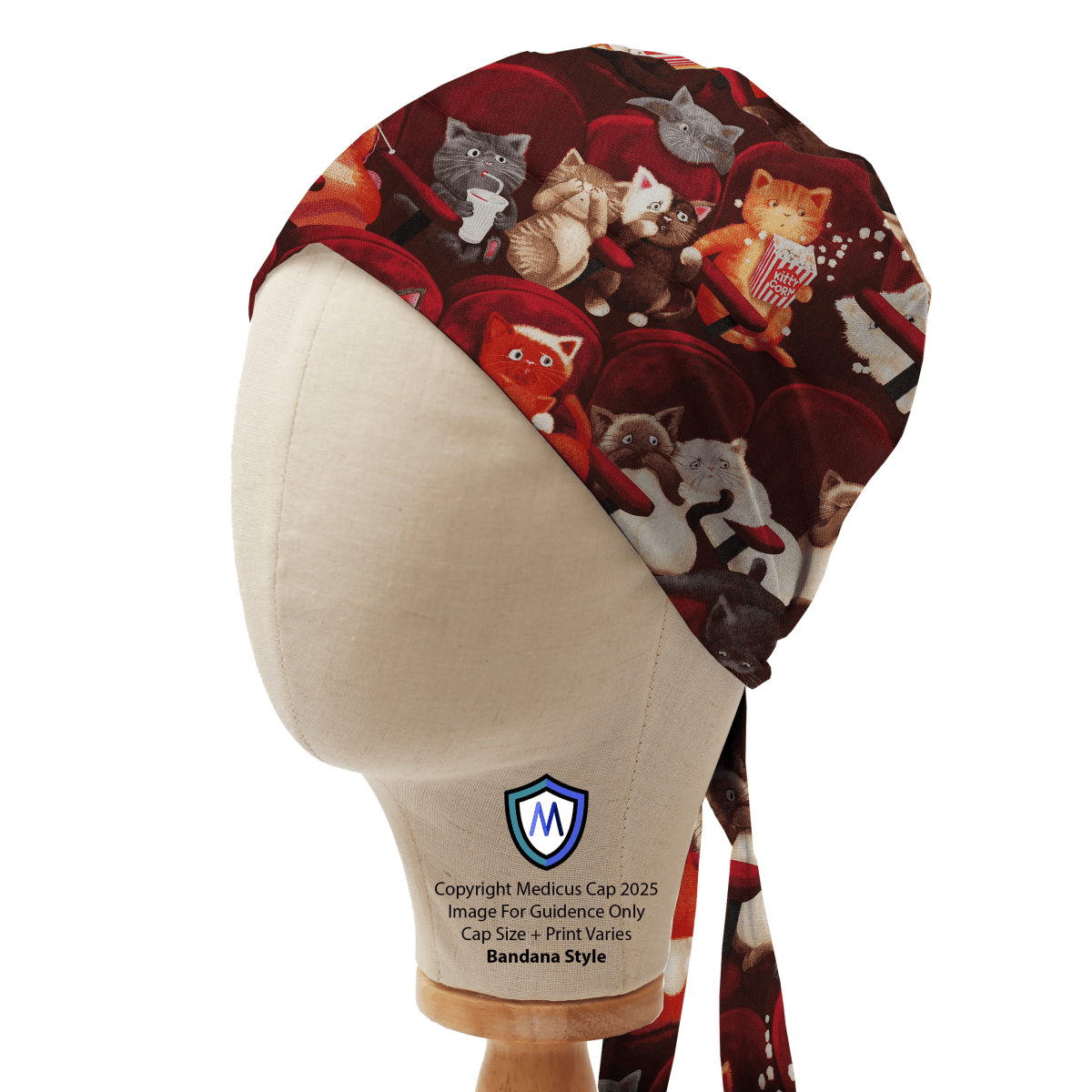 Bandana-style scrub cap by Medicus Caps featuring cats at the cinema on a dark red background, displayed on a mannequin to showcase design and fit.
