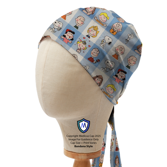 Mannequin head wearing a blue Medicus Scrub Cap with Charlie Brown characters in a grid pattern, bandana style.