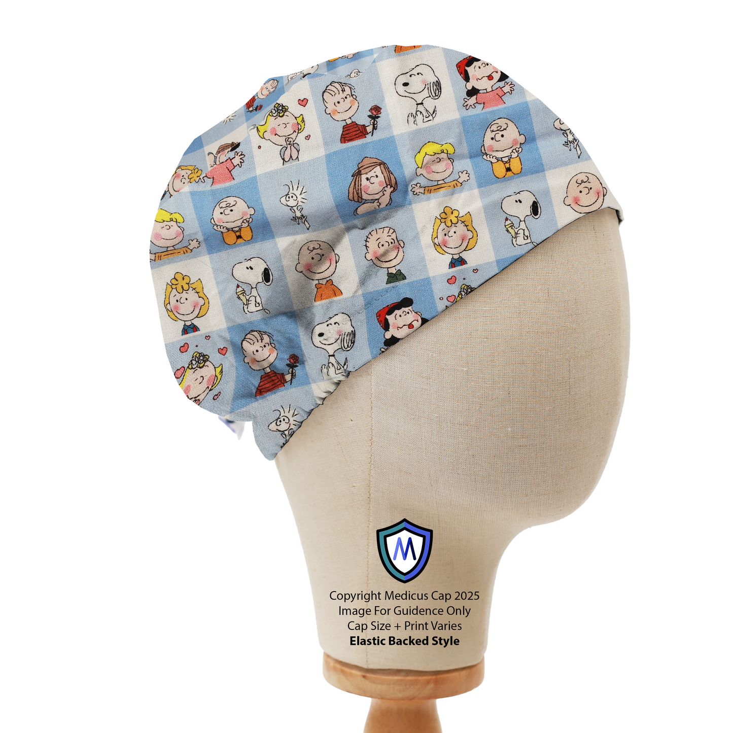 Mannequin head wearing a blue Medicus Scrub Cap with Charlie Brown characters in a grid pattern, elastic backed.