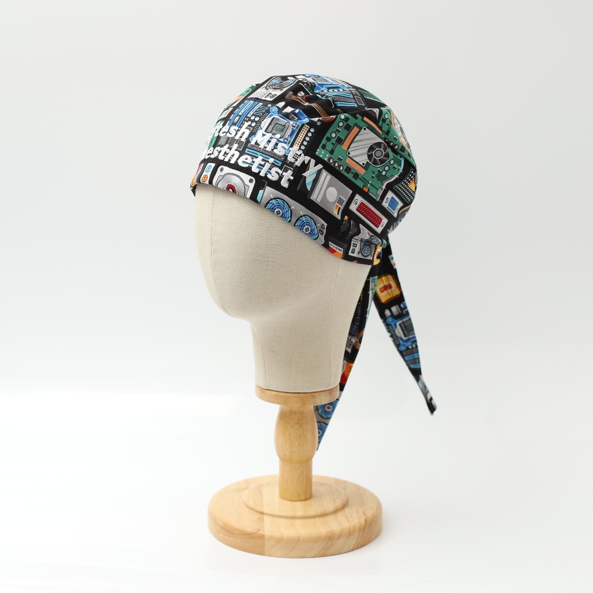 Medicus Scrub Cap with a circuit board and AI computer-themed design, displayed on a mannequin head. Custom text included on the cap.