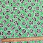 Close-up view of green Starbucks logo pattern scrub cap fabric with measuring ruler