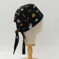Side view of black custom scrub cap featuring coffee and tea-themed illustrations including French press, teapots, grinders and cups. Handmade coffee barista scrub cap by Medicus Caps with tie-back design ideal for medical professionals who love coffee.