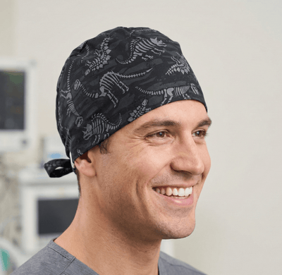 Dinosaur Bones Cartoon Dark scrub cap shown on model
