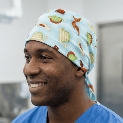 Dinosaurs in a Swamp Light Blue scrub cap shown on model