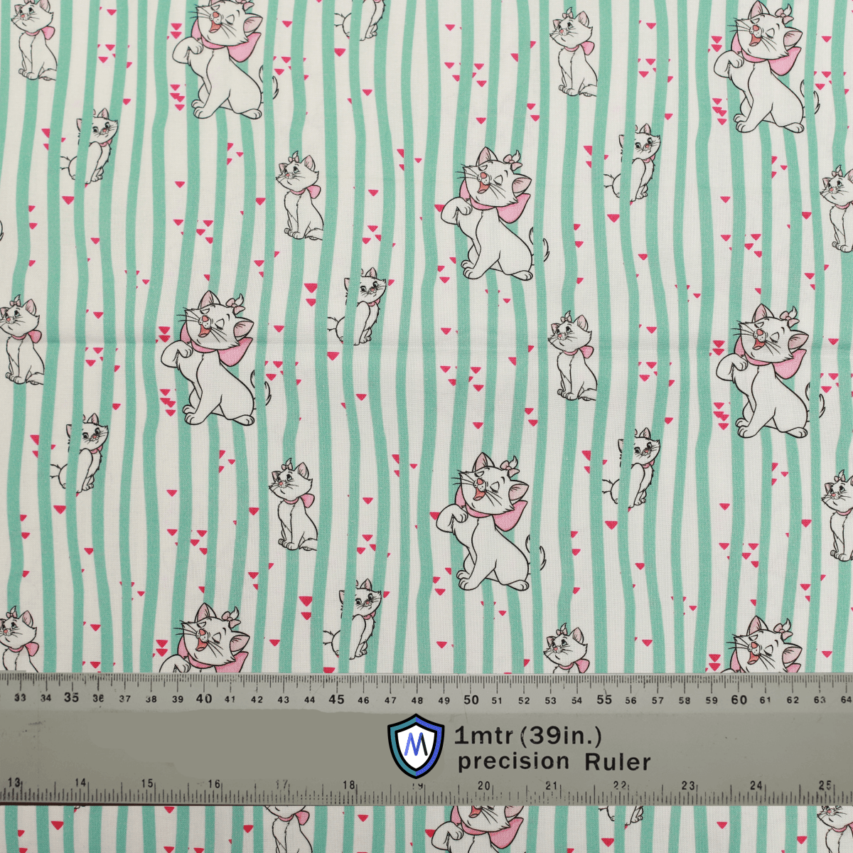 Fabric sample for Medicus Scrub Caps featuring Disney Marie Cat print with green stripes and hearts, shown with a ruler for scale.