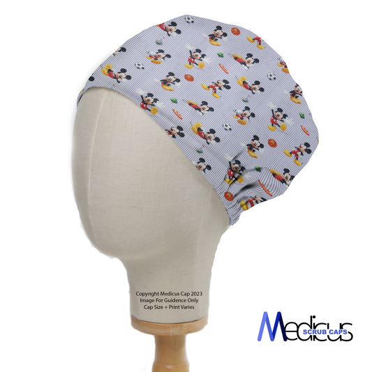 A mannequin head displays a Medicus Scrub Caps Disney Mickey Football Frisbee Scrub Cap, featuring Mickey Mouse playing sports with vibrant fruits on a striped background.