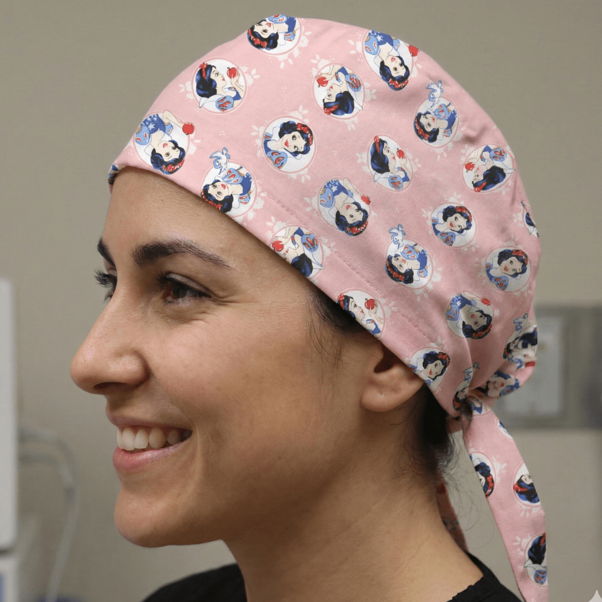 Gorro quirúrgico de princesa Disney Blancanieves sobre fondo rosa