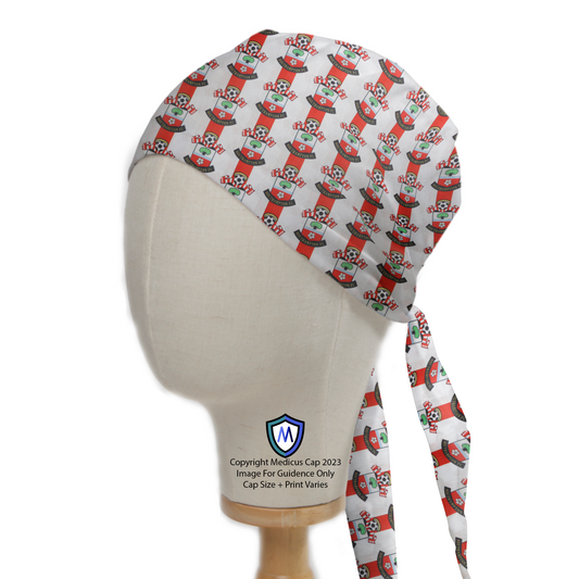 A mannequin head displays the Football Club Southampton FC Scrub Cap by Medicus Scrub Caps, featuring a festive pattern with Southampton FC logos and long ties.